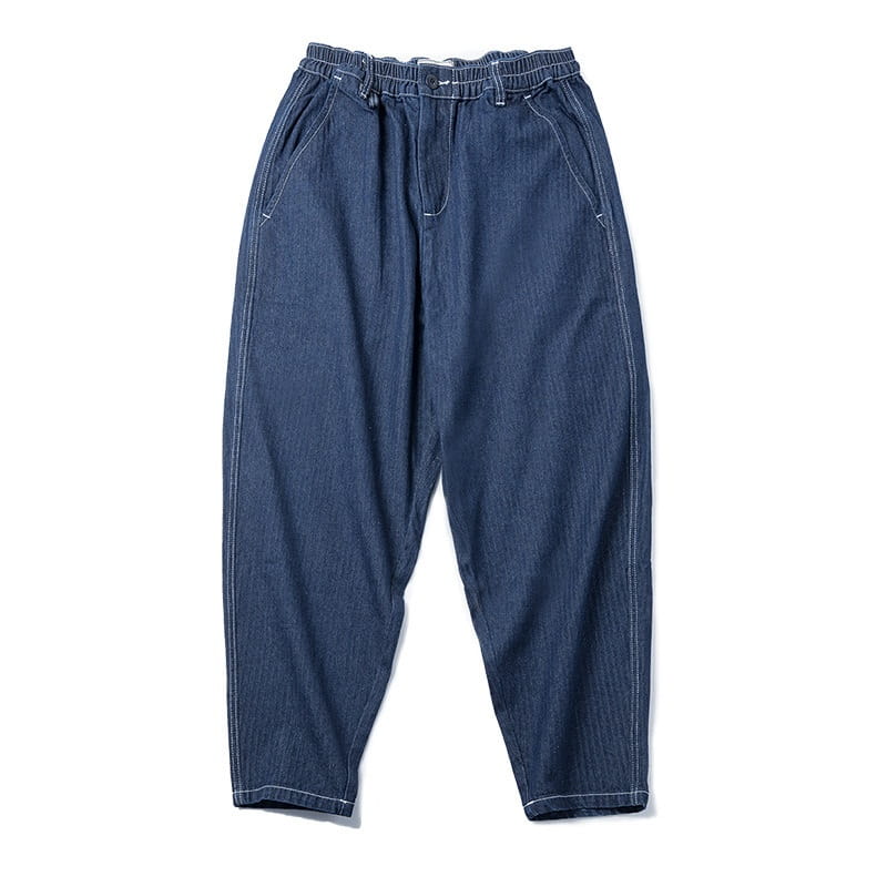 Pantalones vaqueros relajados y cónicos azul marino oscuro para hombre con detalle de parches, con costuras blancas contrastantes a lo largo de las costuras.