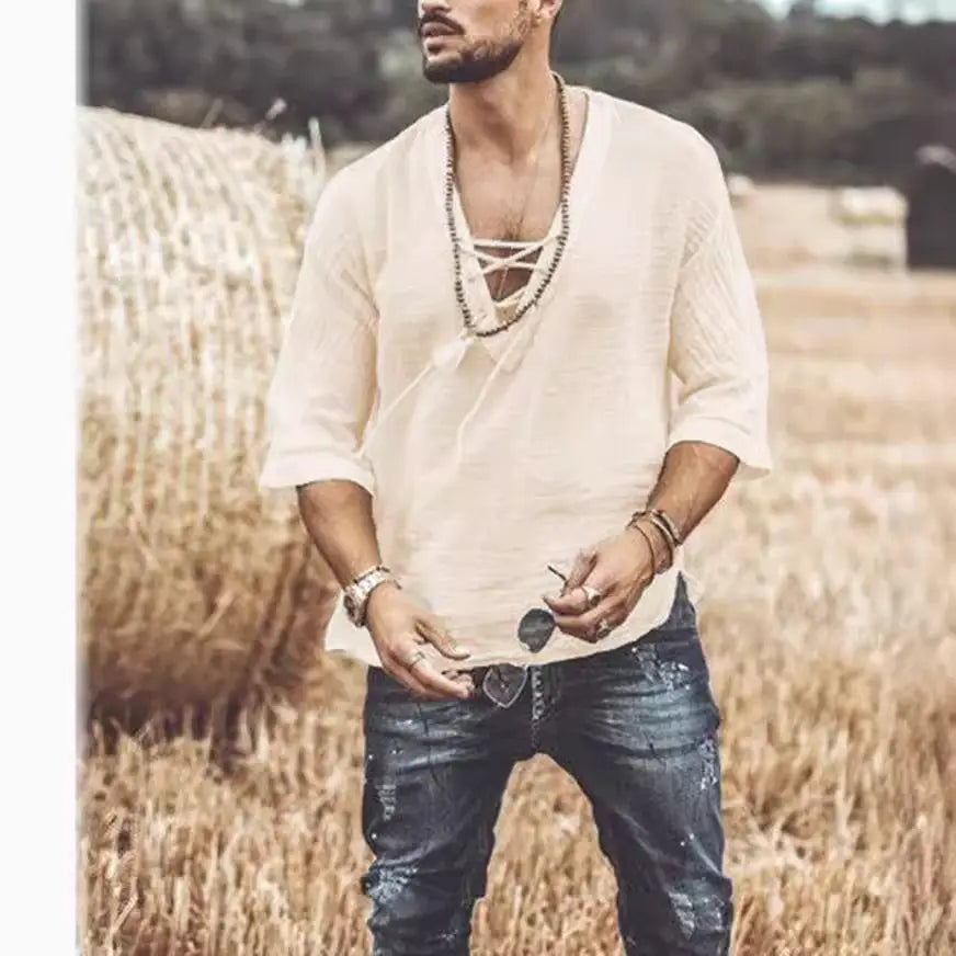 Cream-colored loose-fitting textured linen lace up v neck shirt with rolled sleeves.