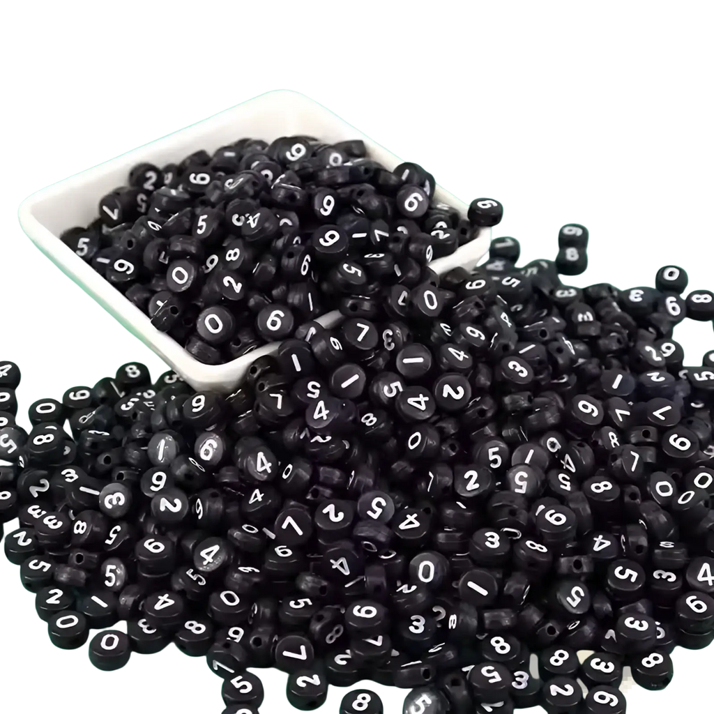 Black cylindrical acrylic beads with white numerals displayed in a white dish from 800 piece bead set