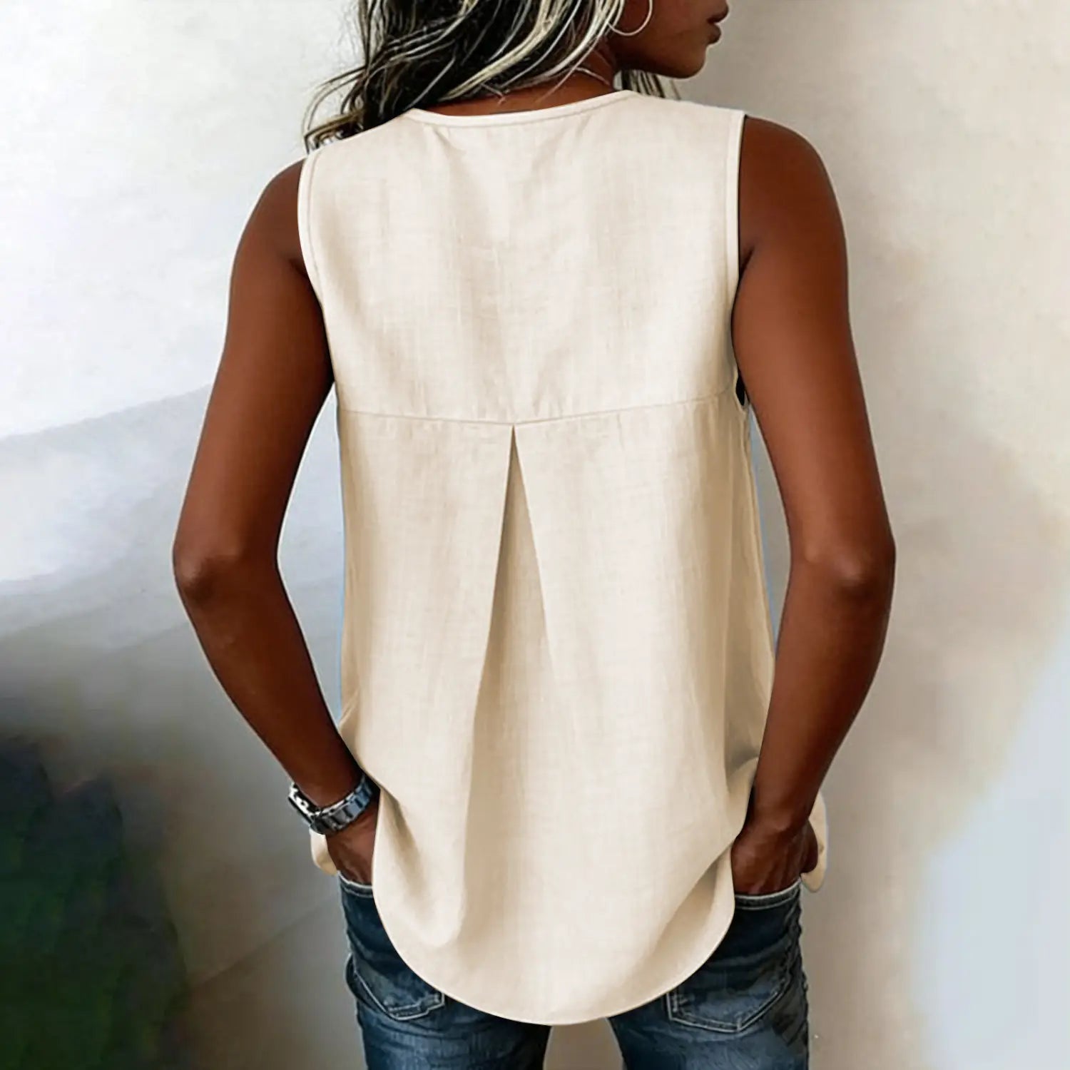 Beige sleeveless tie side button down blouse shown from the back with a relaxed fit and subtle pleating.