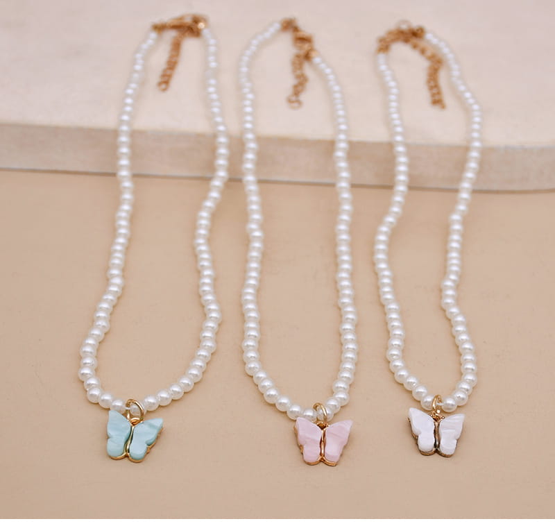 Elegant pearl butterfly charm choker necklaces featuring three delicate pearl strands with pastel blue pink and white enamel butterfly pendants and gold-tone metal accents.