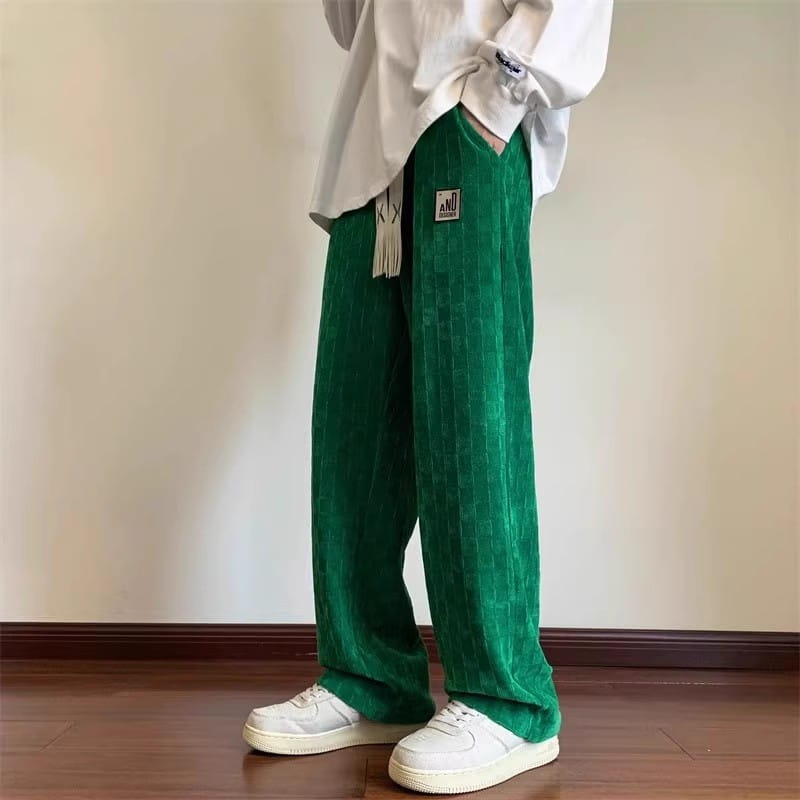 Herren-Schachbrett-Cordhose in Übergröße in Grün mit einem dezenten, strukturierten Muster und einem kleinen rechteckigen Markenpatch am linken Oberschenkel.