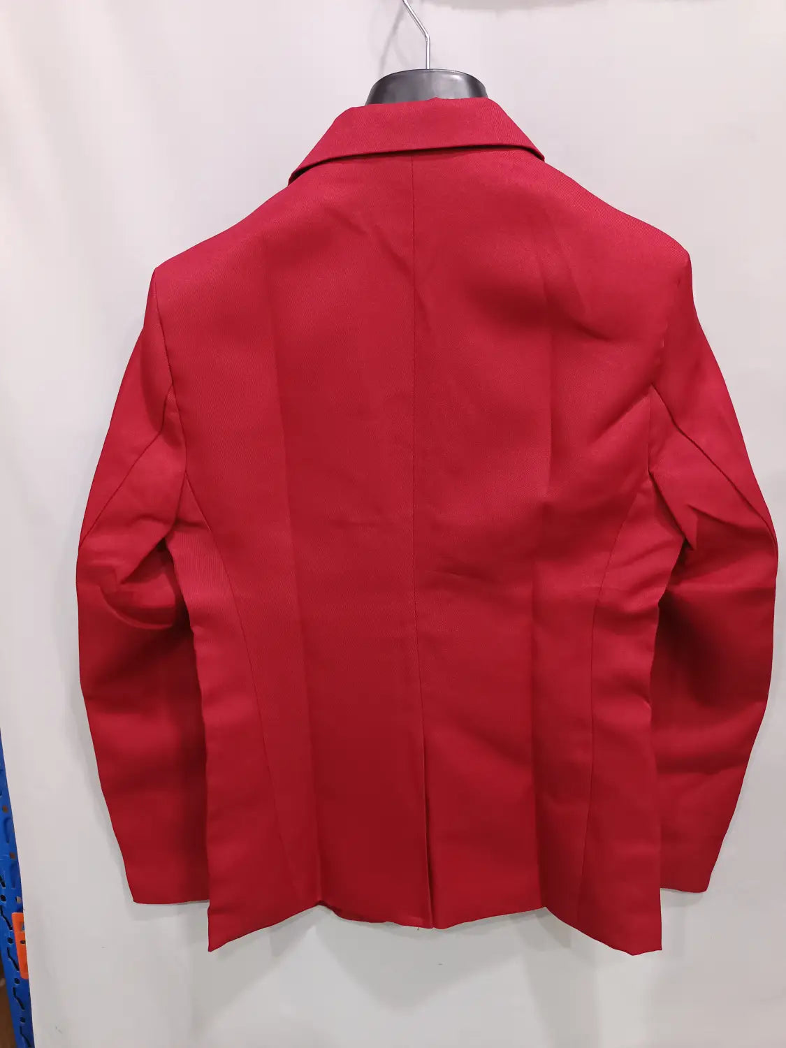 Ein leuchtend roter Herren-Slim-Fit-Fuchsia-Freizeitblazer mit strukturierter Passform und Reverskragen, dargestellt auf einem Bügel.