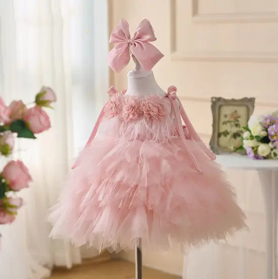 Robe de cérémonie de fille d’honneur en tulle rose à motif floral à tutu, avec bandeau noué assorti, présentée de face.