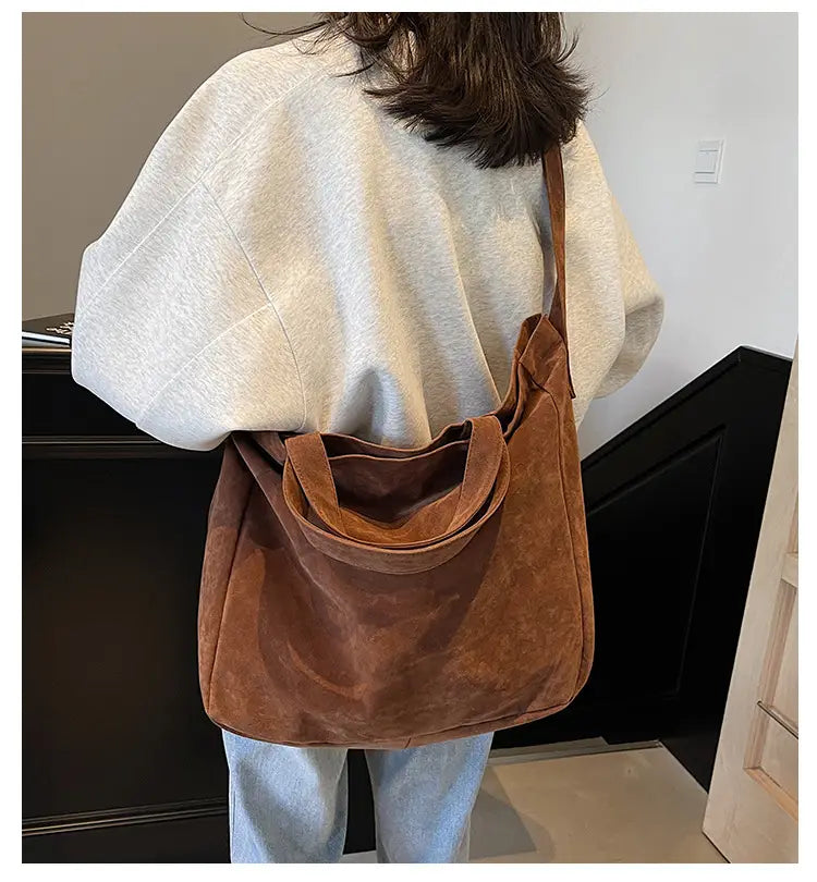 Brown suede tote bag with a soft textured finish and wide corduroy shoulder handles.
