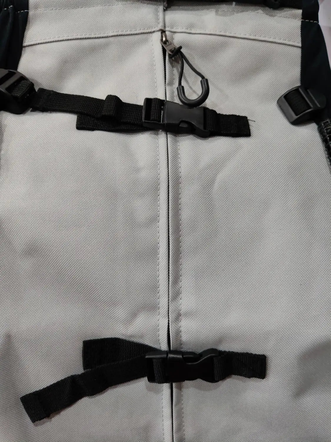 Light gray canvas breathable dog backpack mesh pet carrier with black webbing straps and plastic buckles shown from the back side.