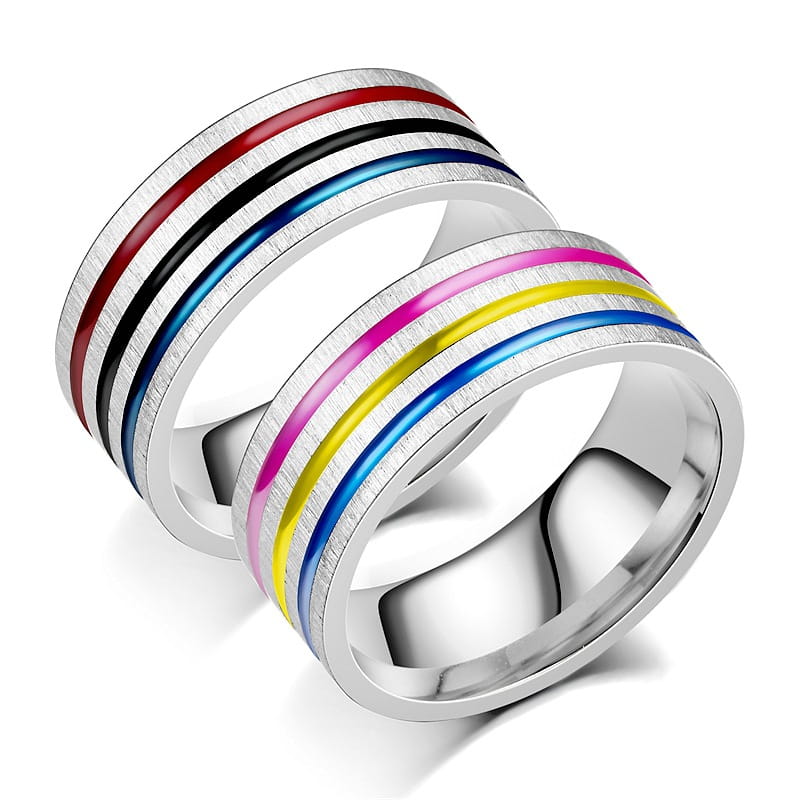 Two stainless steel unisex band rings with brushed metallic surfaces featuring vibrant rainbow enamel inlay stripes in red black blue pink yellow and purple.