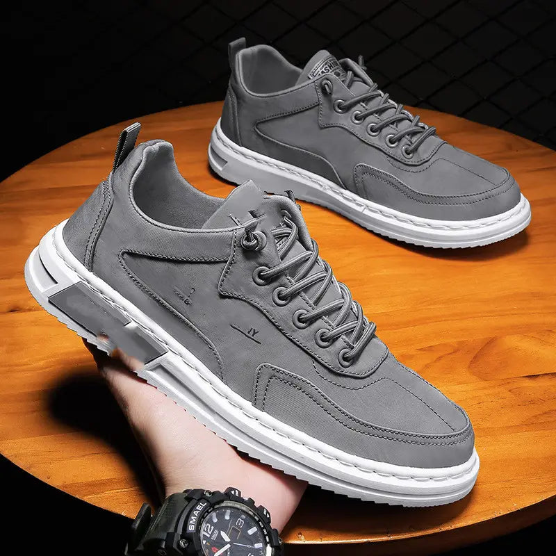Gray suede and canvas canvas sneakers with white rubber soles and laces featuring a modern athletic design for casual sports use.