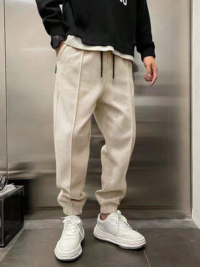 beige fleece men’s drawstring sweatpants with textured fabric, elastic cuffs, and a drawstring waist.