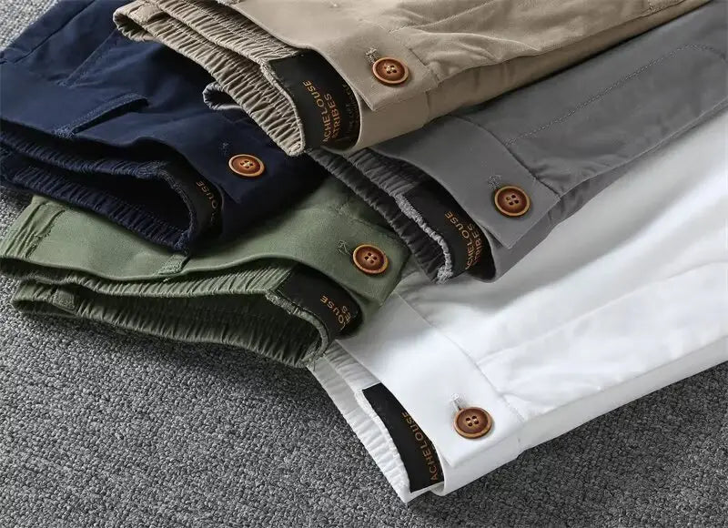 Men casual slim fit cargo shorts in navy beige olive green and white with elastic waistbands and brown wooden buttons stacked together.