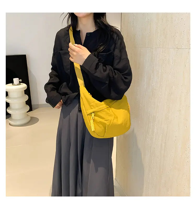 Bright yellow canvas nylon crossbody bag with braided drawstring closure featuring large capacity for hobo style shoulder use.