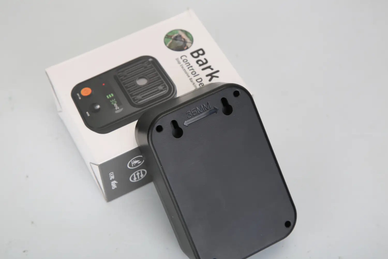 Ultrasonic anti-barking device ipx4 waterproof trainer showing the back side of a black plastic bark control device with a matte finish and two mounting holes.