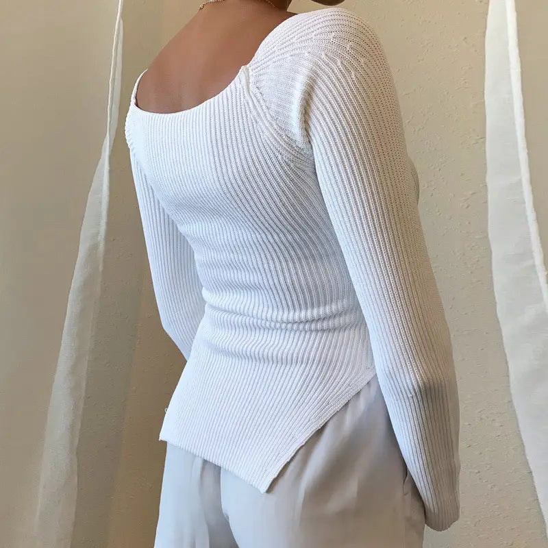 A white ribbed knit long-sleeved top with a square neckline and asymmetrical hem designed as a ribbed sweetheart neck long sleeve knit pullover.