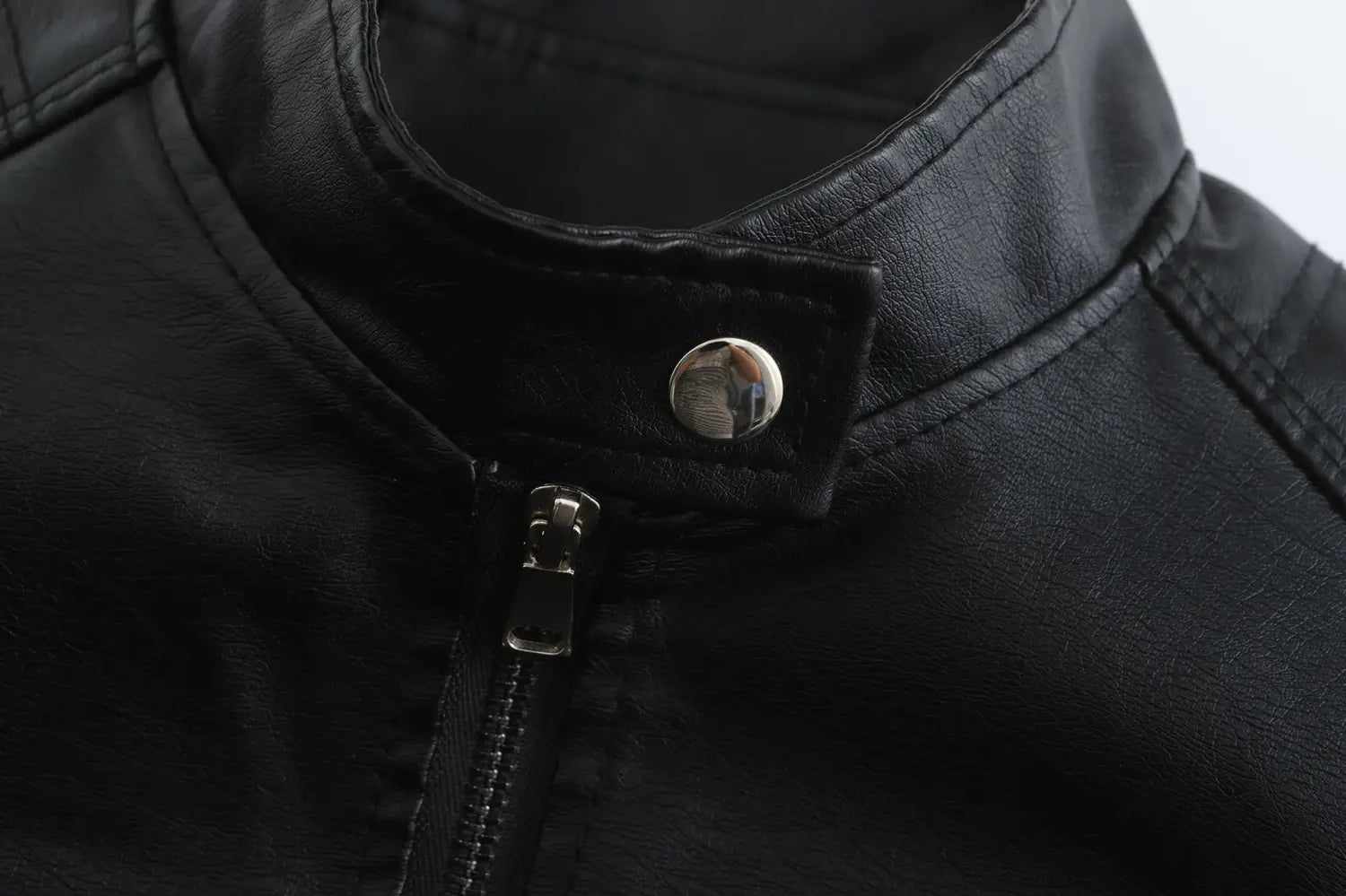 Veste motard en faux cuir noire avec bouton-pression argenté et fermeture éclair, arborant un col montant