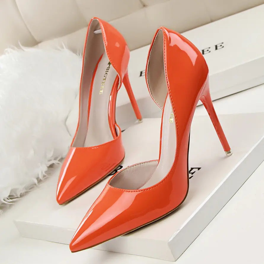 Vibrant orange patent leather pointed toe stiletto high heels with a sleek design and thin heel.