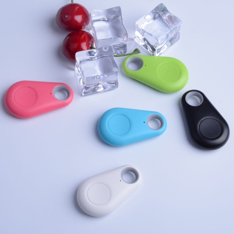 ピンク・緑・青・黒・白のカラフルで洗練されたBluetoothトラッカーのセット。滑らかなプラスチックボディと、発光リチャージャブルLED犬用首輪のペット安全ライトを並べて表示。