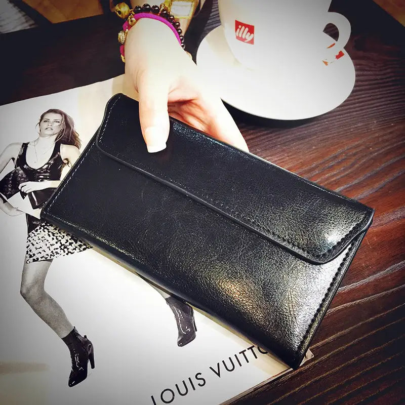 Black leather retro slim cowhide leather flap wallet with a smooth slightly textured surface and contrast stitching along the edges.