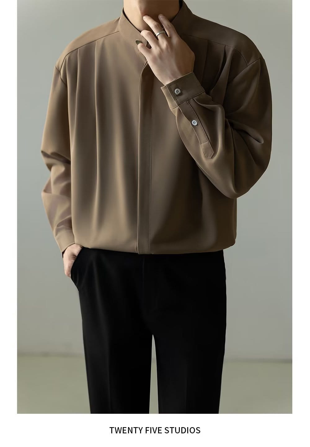 Chemise plissée pour homme à col montant marron mat et élégante, à manches longues, coupe ample détendue et plis subtils.