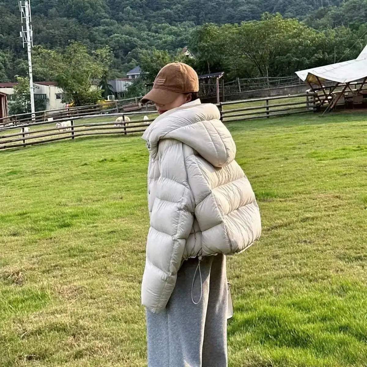 Chaqueta acolchada de plumón acolchada color crema con capucha y cintura con cordón, diseñada para mujer como chaqueta de plumón de invierno.