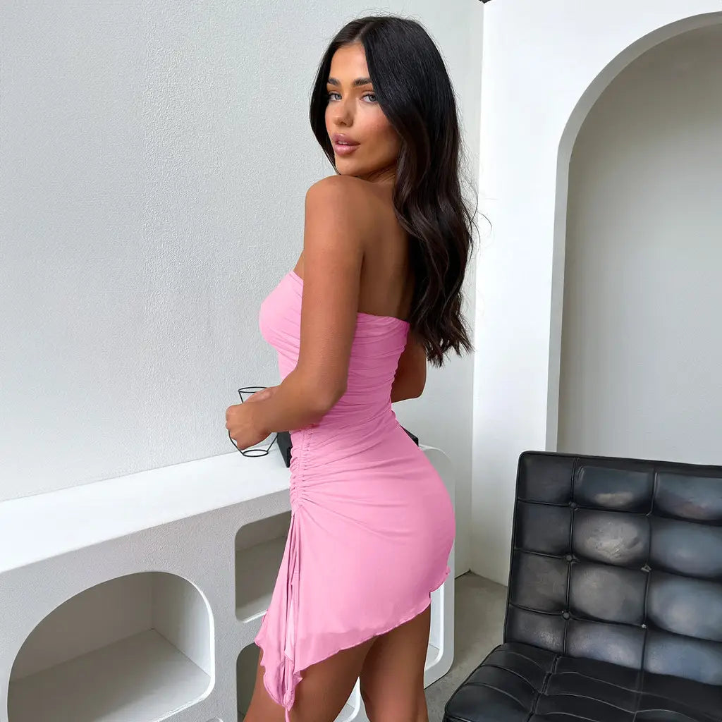 a strapless, form-fitting pink mini dress with a ruched back and asymmetrical hemline shown from the back in the y2k ruched strapless side slit mini dress style