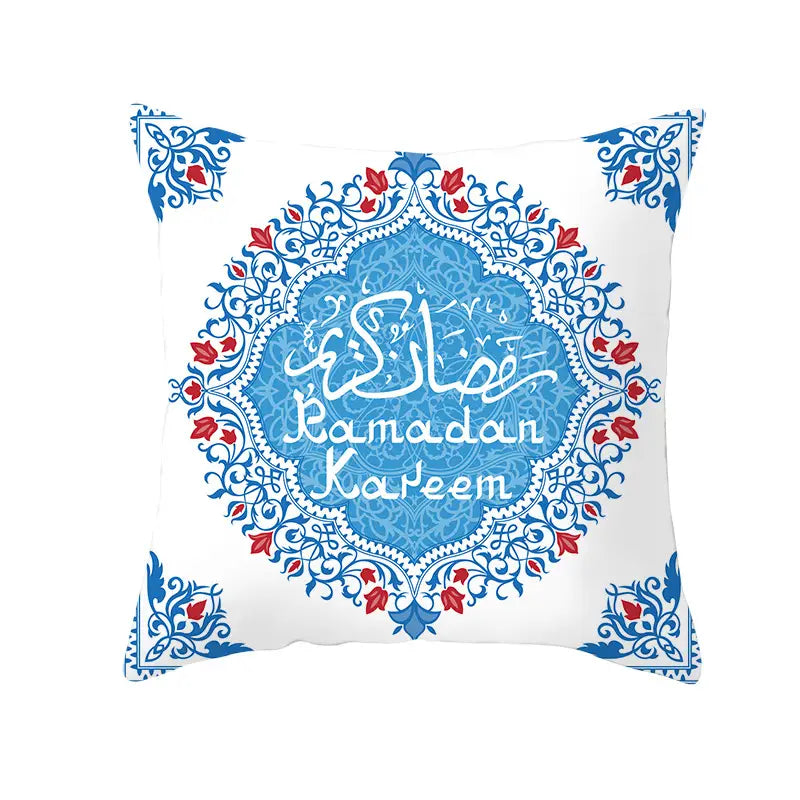 Cojín decorativo blanco con intrincados patrones ornamentales en azul y rojo con caligrafía árabe que dice Ramadan Kareem en un diseño de medallón central para la decoración de Eid.
