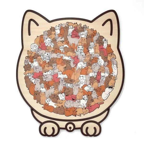 Una alfombra de rompecabezas de madera con forma de gato color beige que presenta 135 gatos ilustrados coloridos en diversas posturas y tonos como parte del juguete rompecabezas Morandi del gato de madera.