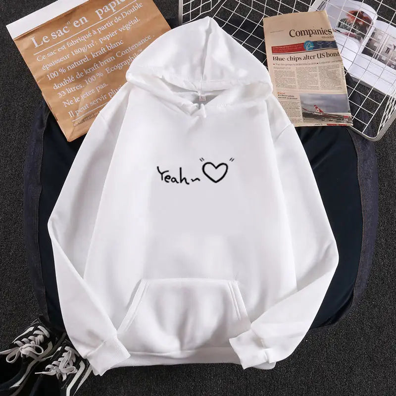 Sudadera con capucha aislada y forro polar blanca, con un gráfico de corazón 'yeah' negro en el pecho.