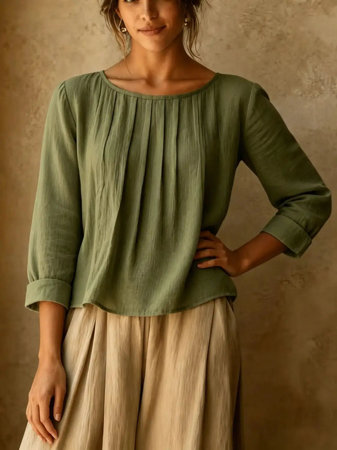 Une blouse ample en lin et coton pour femmes, vert olive, avec de doux plis, manches trois-quarts et poignets retroussés.