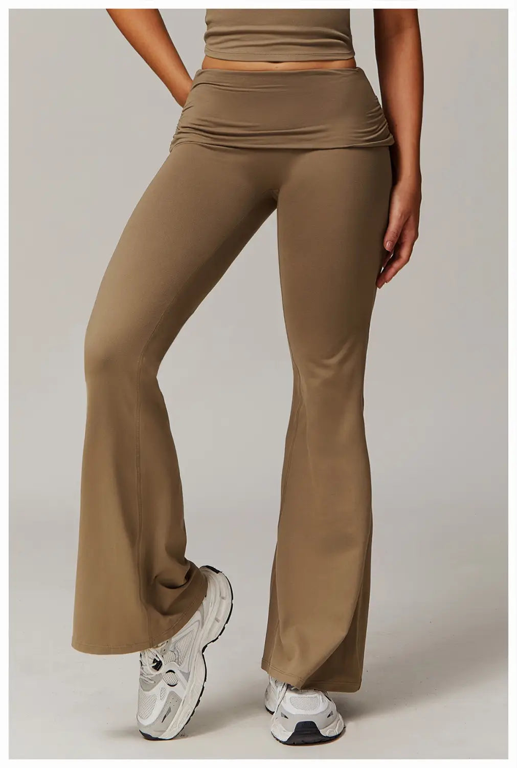 pantalones de yoga acampanados de cintura alta color arena hechos de tejido elástico ceñido para un atuendo activo cómodo.