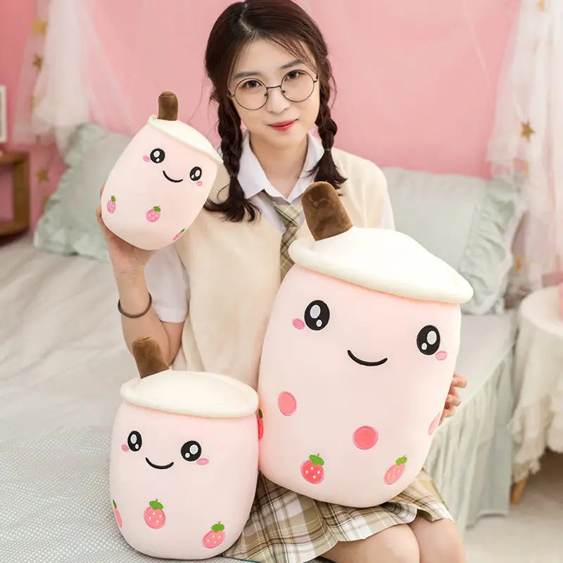 coussin moelleux en forme de thé aux perles boba, rose, présentant des motifs kawaii de fraise et des sommets de paille brune, conçu comme un accessoire en forme de lait de thé aux fruits