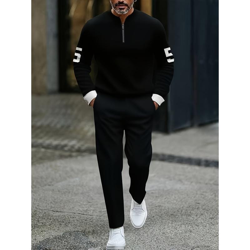 Black half zip athletic sweater with white numerals on the sleeves and contrasting white cuffs in a printed sweatsuit set.