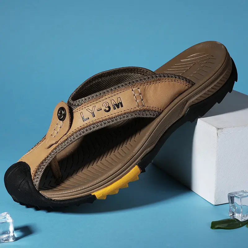 Men’s leather beach sandals outdoor sport flip flops in tan leather and mesh with a rugged black rubber sole yellow accent on the heel and ly-3m branding.