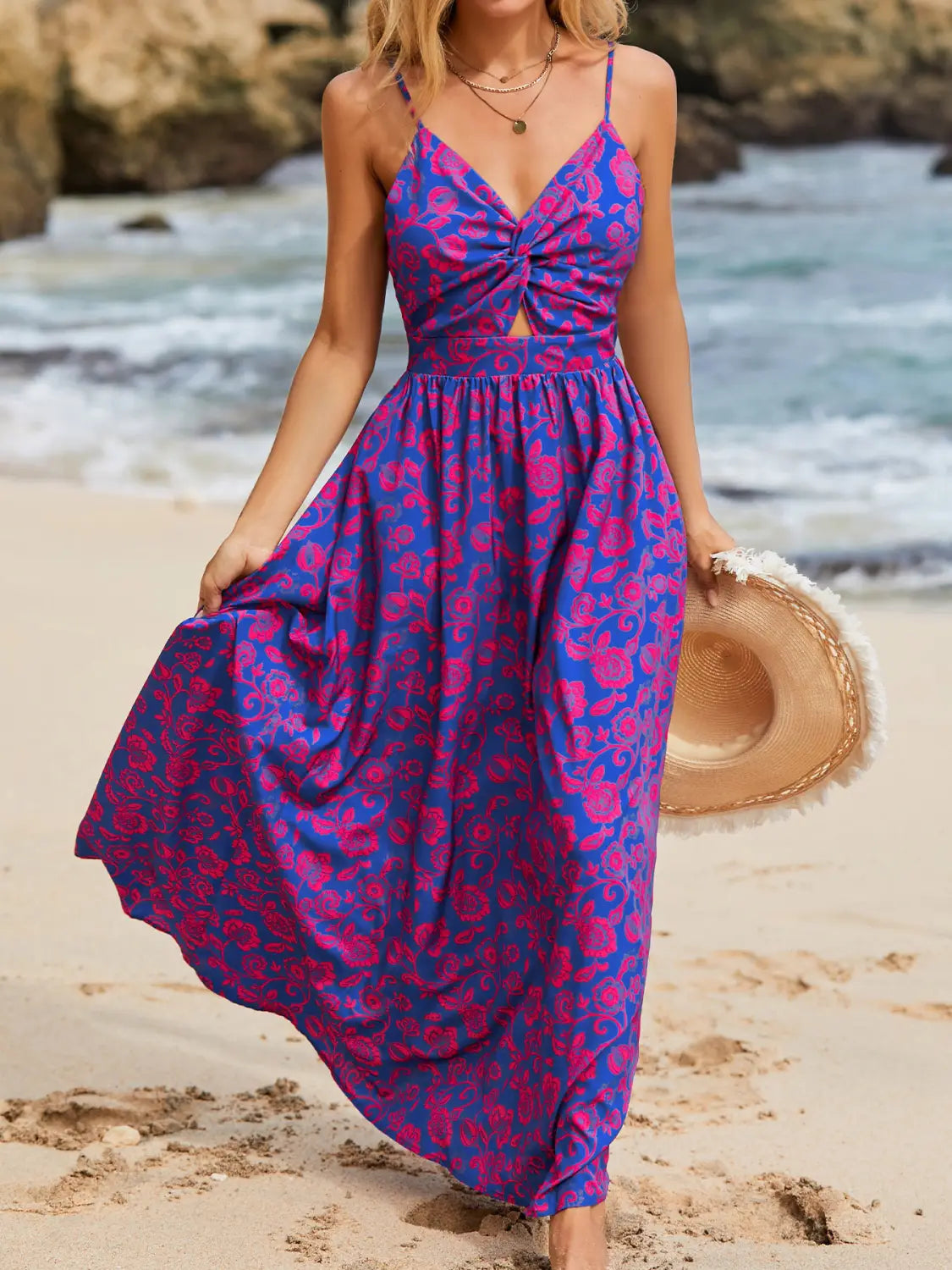 A flowing vibrant purple and magenta floral print maxi dress with a halter neckline and front knot detail.