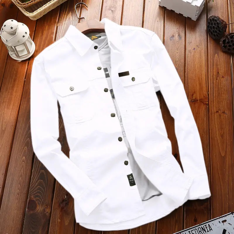 Chemise d’homme d’extérieur à manches longues boutonnée unie blanche, avec deux poches de poitrine et des boutons foncés.