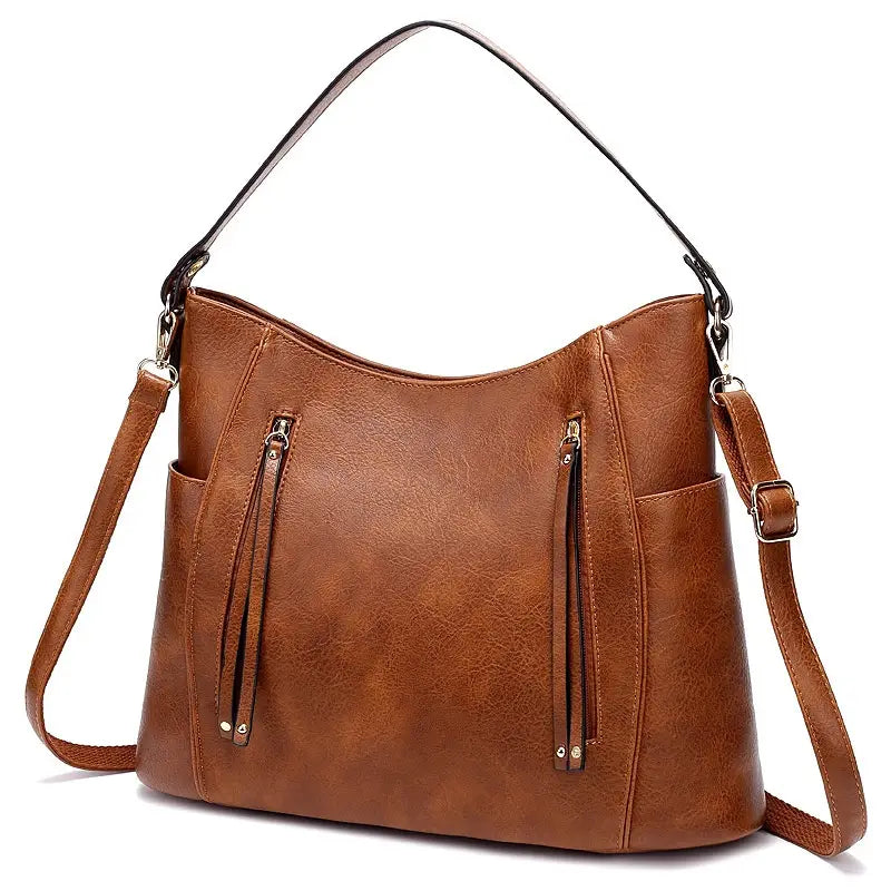 brown faux leather leather hobo bag with tassel featuring an adjustable shoulder strap and front zippered pockets