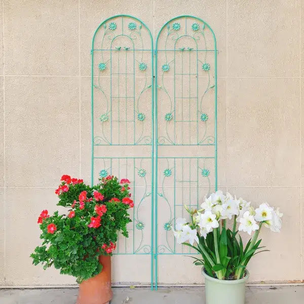 A turquoise metal garden trellis with an arched top and floral embellishments designed for climbing plants in a 4 pack set.