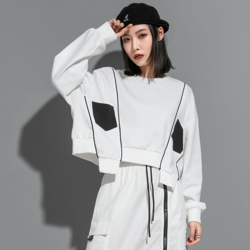Sweat-shirt court blanc à poches patch noires géométriques et lignes de couture contrastantes, issu de la collection de pull à capuche irrégulier en patchwork pour vêtements pour femmes.