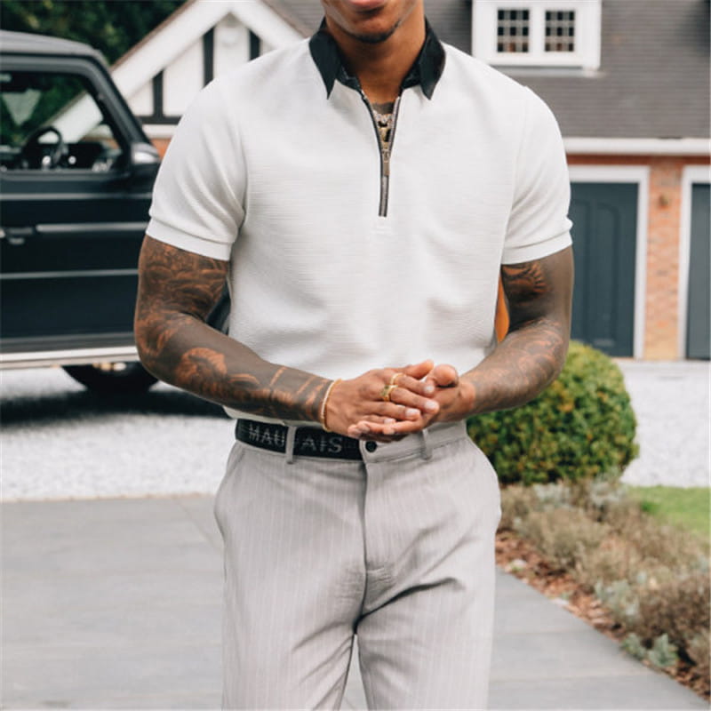 White short-sleeved textured men’s polo shirt with black contrast collar and zipper placket.