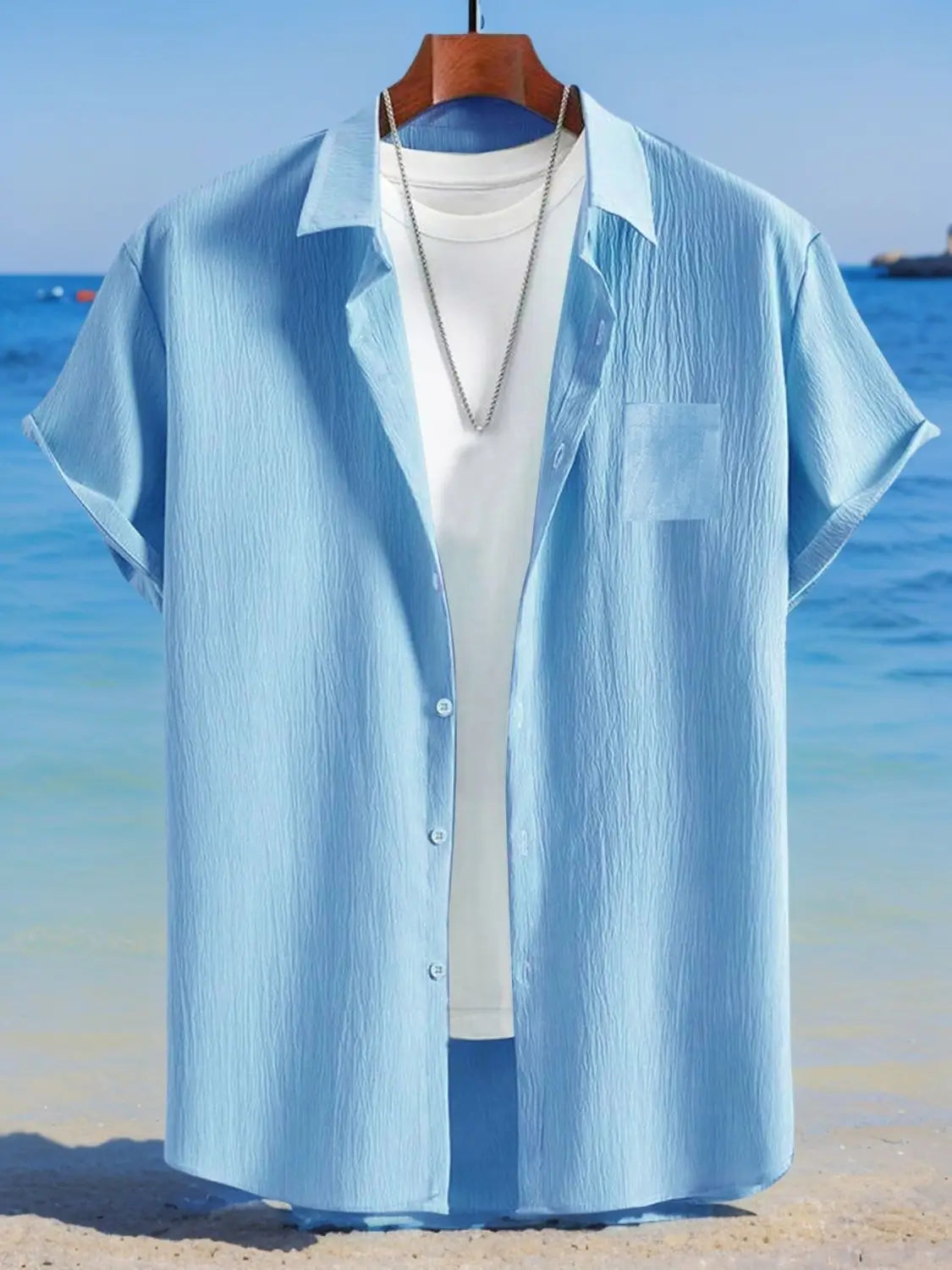 chemise en lin bleu clair boutonnée, manches courtes, tissu à texture subtile et poche poitrine, conçue comme un haut ample et décontracté pour homme.