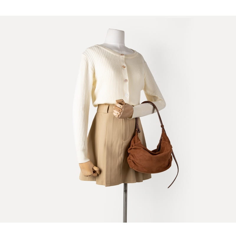 Brown suede dumpling shoulder bag with a long strap featuring a slouchy hobo crossbody design.