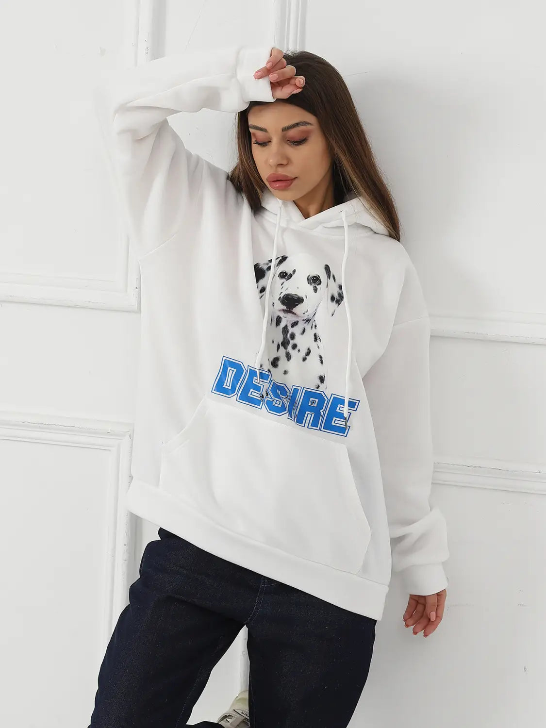 white women’s hoodie featuring a black and white dalmatian graphic and bold blue desire lettering across the chest with a cat ear hood.