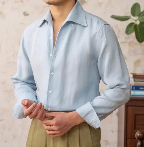 Ein hellblaues Lyocell-Leinen-Freizeithemd für Herren mit klassischem Kragen und weißen Knöpfen.