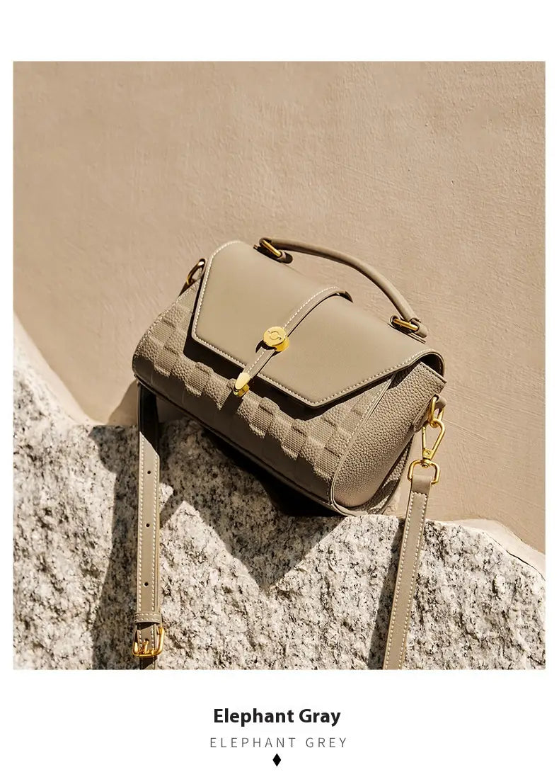 Elefantengraue zweifarbige Webleder-Crossbody-Handtasche mit strukturiertem Muster und goldtönigen Beschlägen.