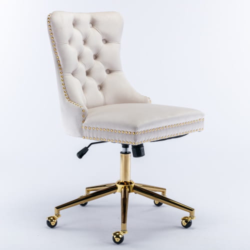 Silla de oficina de terciopelo color crema con botones tipo capitoné, marco metálico de tono dorado y ruedas giratorias, diseñada para un uso cómodo en el espacio de trabajo.