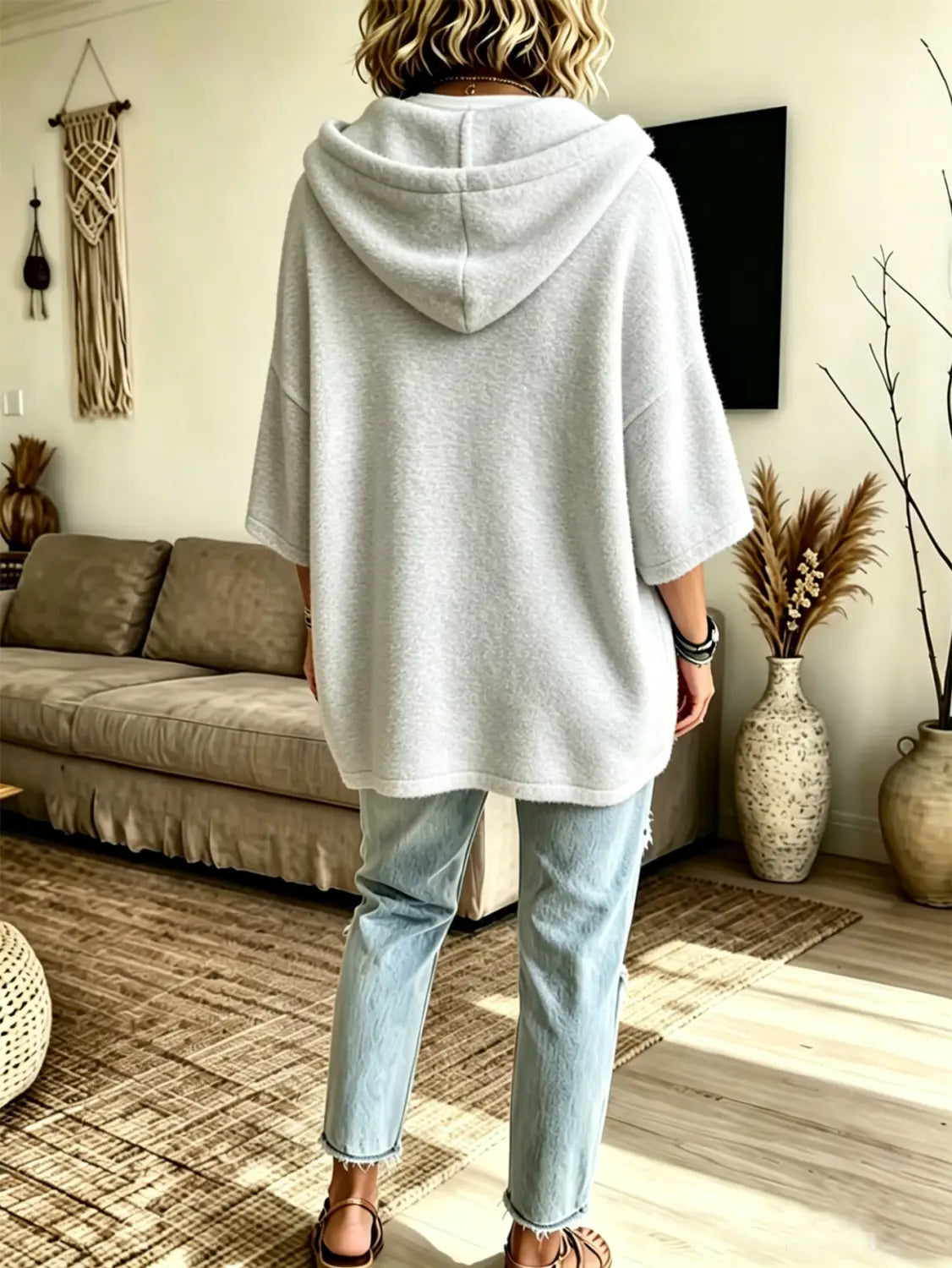 A soft light gray oversized fleece hooded top with a relaxed fit and three-quarter sleeves.