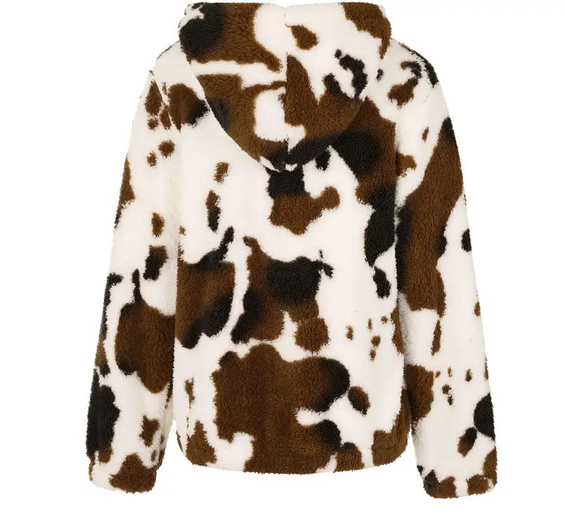 Una chaqueta acolchada tipo zip-up blanca, marrón y negra con estampado de vaca, hecha de material polar.
