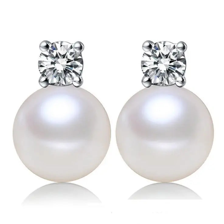 Elegant white pearl and cubic zirconia silver stud earrings featuring a round lustrous white pearl and a clear faceted diamond set in silver-toned metal.