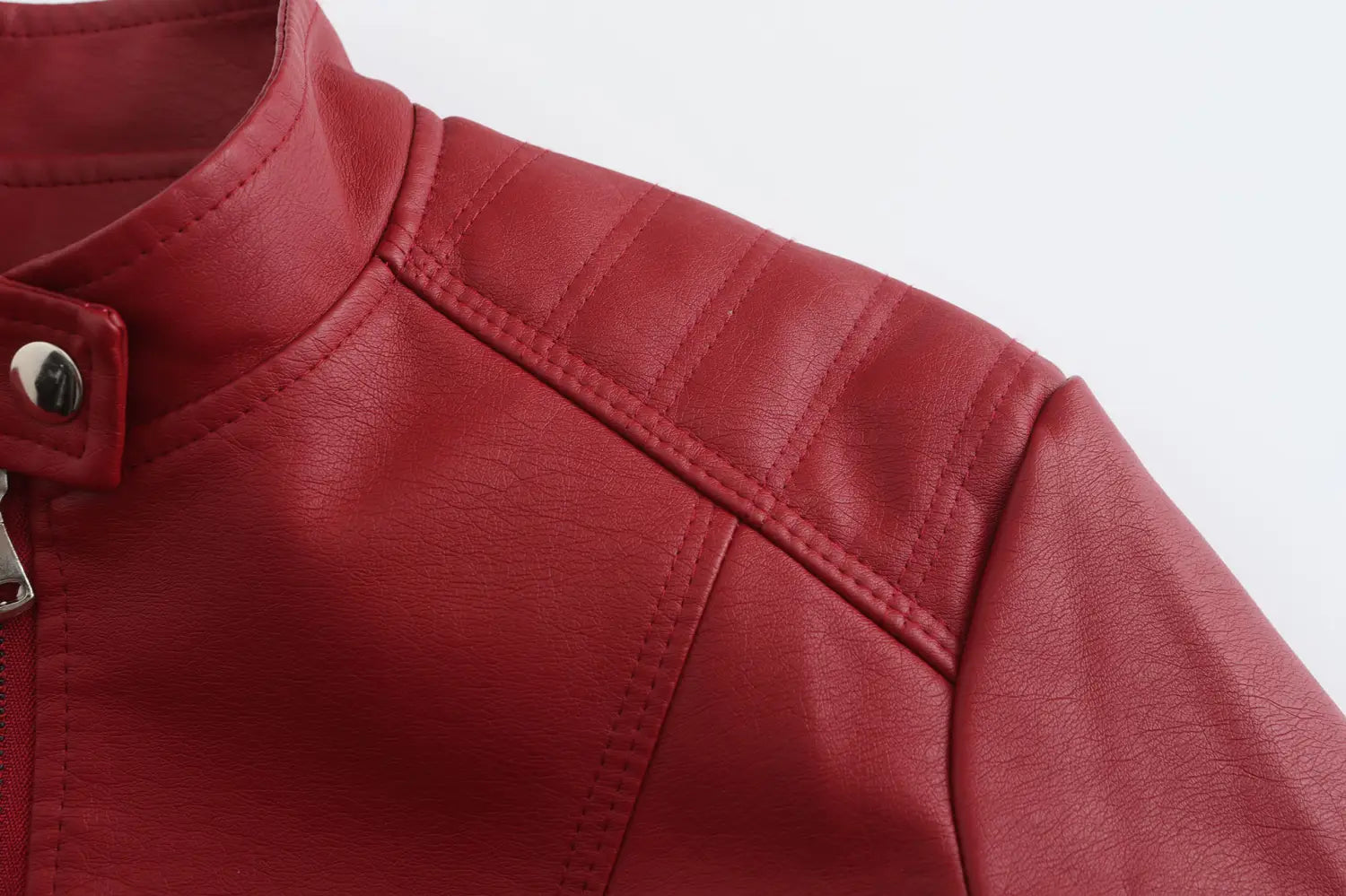 Veste motard en faux cuir rouge avec col montant, panneaux d’épaules matelassés et bouton-pression à tonalité argentée.