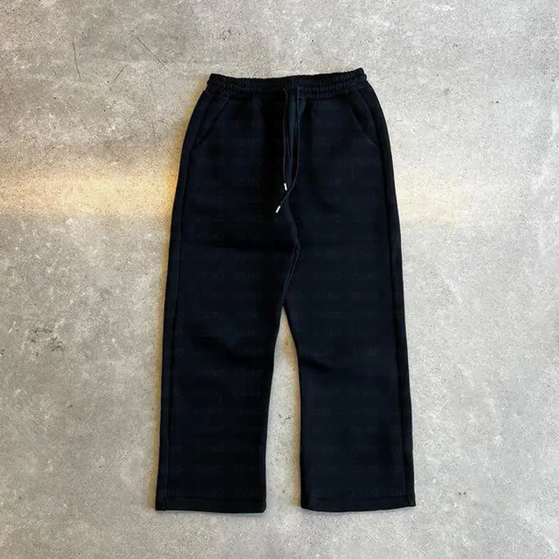 Pantalon de survêtement noir en polaire, avec ceinture élastique et cordon de serrage, issu de l’ensemble oversize unisexe streetwear comprenant un sweat à capuche et un pantalon de survêtement.