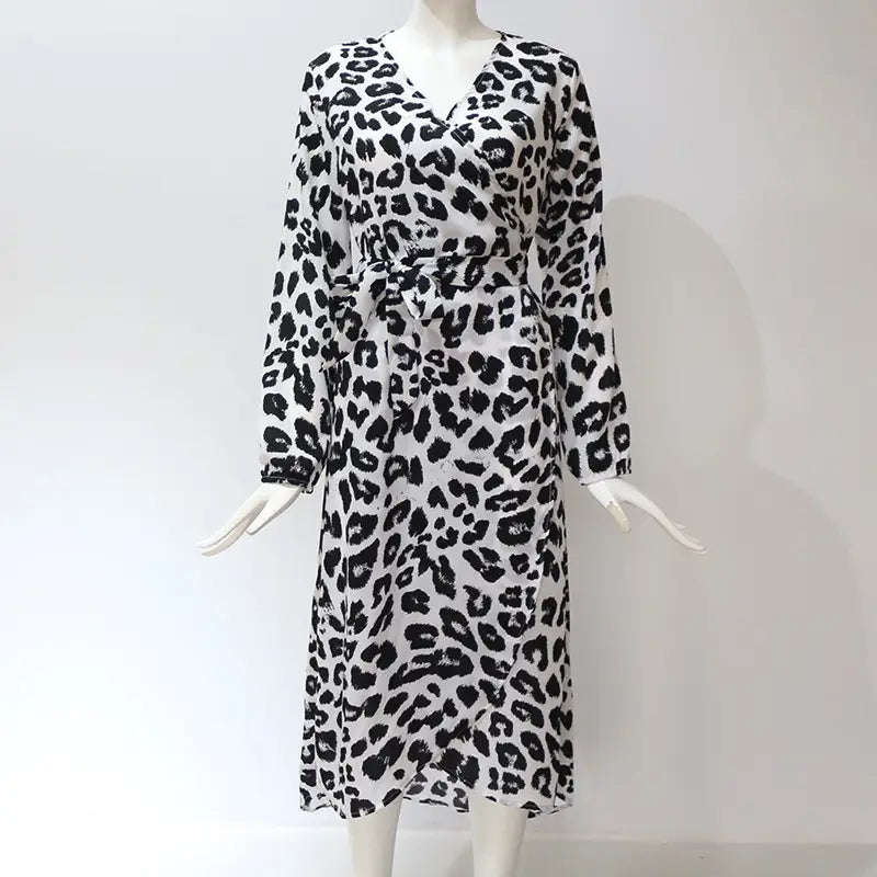 A black and white leopard print chiffon wrap dress with long sleeves and a belted waist featuring a v neck.
